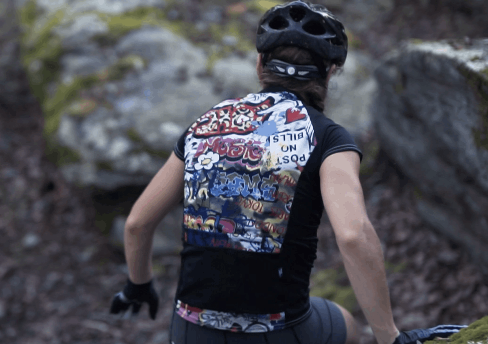 Moxie Tee Jersey with graffiti design, black sleeves, worn by cyclist outdoors.